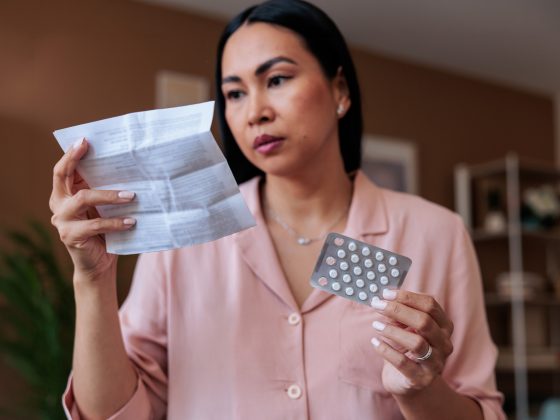 Woman reading instructions for her Hormone Replacement Therapy pills.